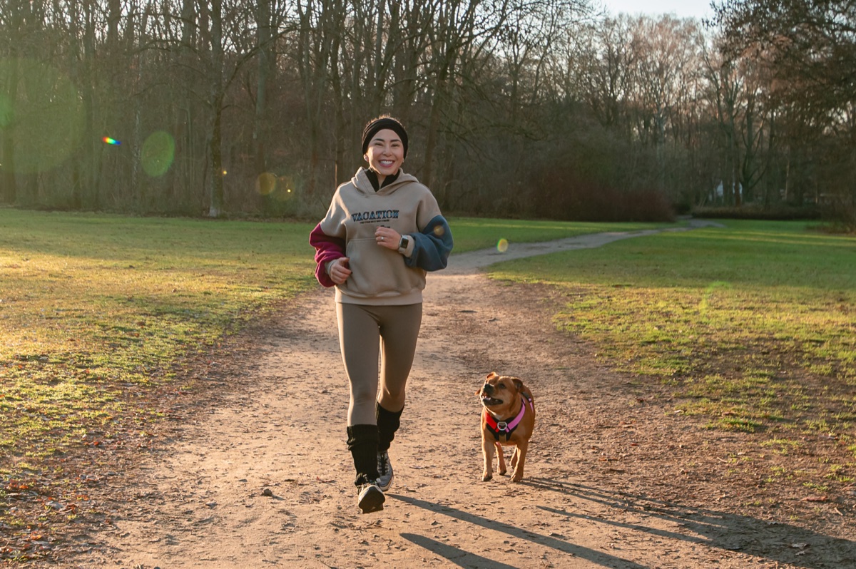 Andrea corriendo con su perro, sonriendo